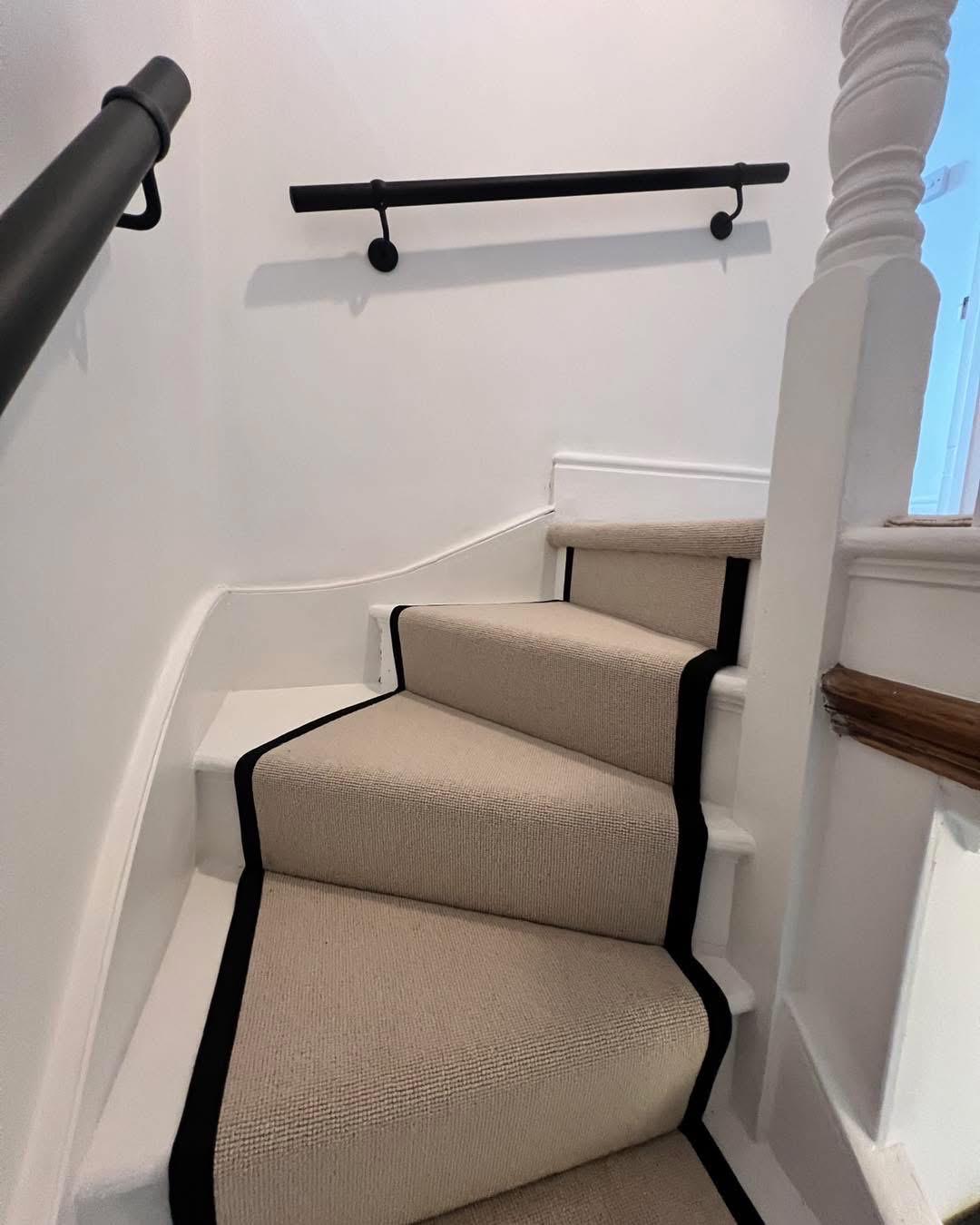 Beige Berber stair runner with black stitched taped edge