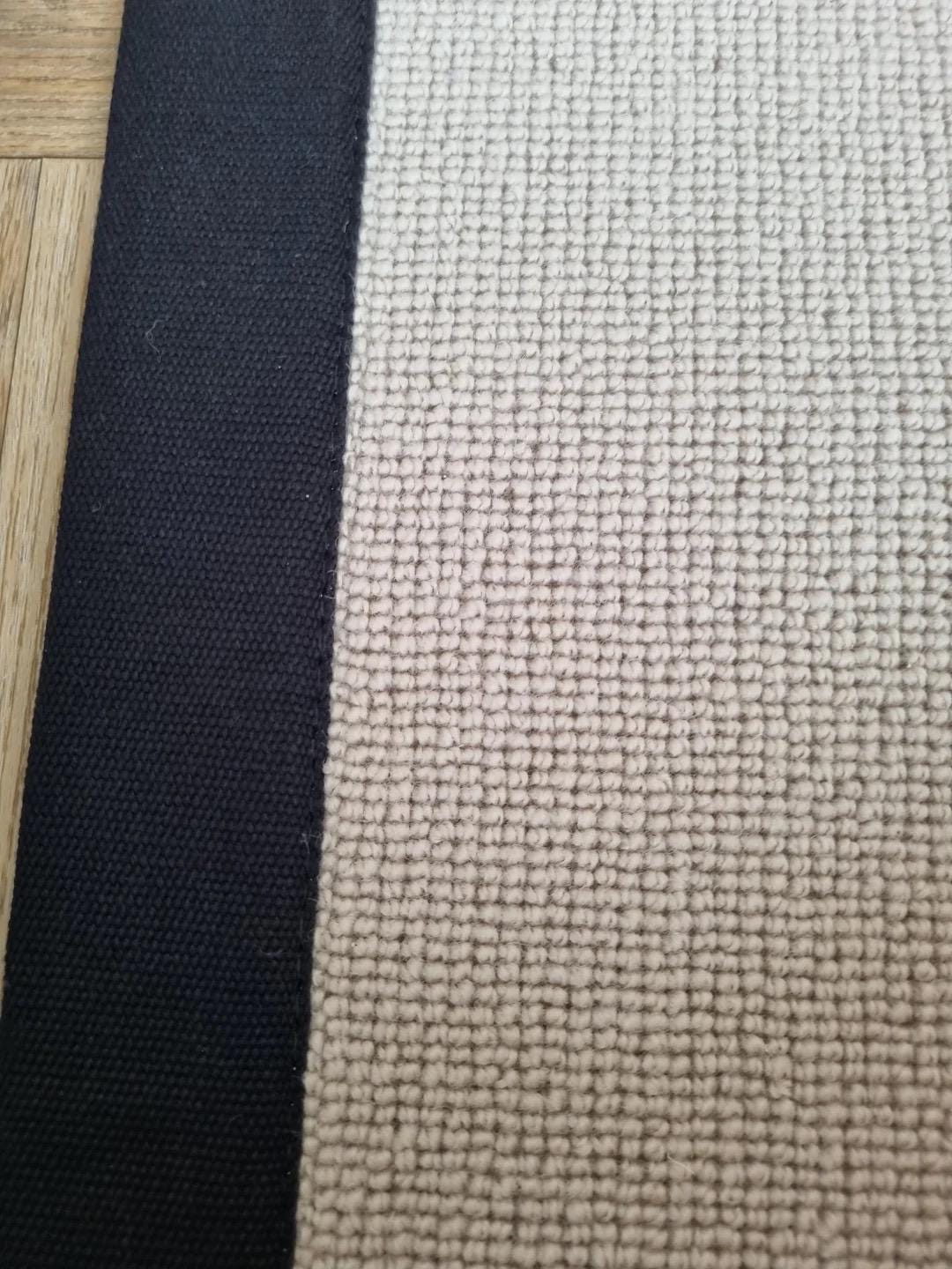 Beige Berber stair runner with black stitched taped edge